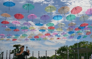 夏空に映える色とりどりの傘の下、シャボン玉の演出を楽しむ子どもたち＝１９日午後、淡路市夢舞台