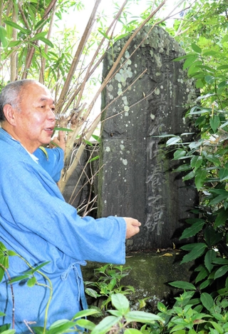 境内の石碑「関東震災横死供養之碑」について説明する安楽寺の内海裕隆住職＝加古川市志方町細工所