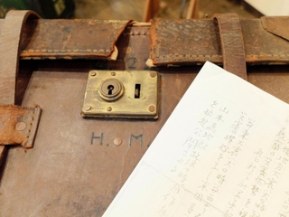 「Ｈ．Ｍ．」のイニシャルのあるカメラケースと震災撮影の来歴を記した便箋（コピー）