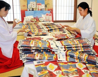 子どもたちの健康を祈り、千歳飴の袋詰め作業に取り組む巫女ら＝中央区下山手通１、生田神社
