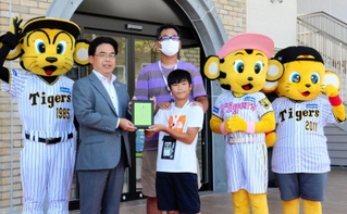 １５０万人目の入館者となり、記念撮影をする小岩隼真君（中央）＝２９日午前、甲子園歴史館