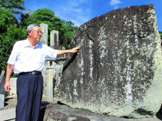 辞世の句が刻まれた石碑と、孫の秀一さん＝南あわじ市倭文長田