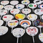 石川県の子どもらがうちわに描いたカラフルな絵や、「友」「愛」などのメッセージ（ＣＯＤＥ提供）