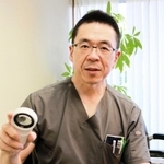 メラノーマの診断に使う特殊な拡大鏡「ダーモスコープ」を手にする高井利浩医師＝明石市北王子町、兵庫県立がんセンター