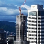 工事用のシートが外され、鉄骨の足場が西日を受けて輝く神戸ポートタワー＝７日午後、神戸市中央区東川崎町１から波止場町方面を望む