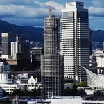 工事用のシートが外され、鉄骨の足場が西日を受けて輝く神戸ポートタワー＝７日午後、神戸市中央区東川崎町１から波止場町方面を望む