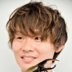 飼育するヘラクレスオオカブトを手にのせるむし岡だいきさん＝東京都港区