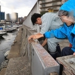 台風７号が兵庫を直撃する恐れが高まり、兵庫県の指示を受けて慌ただしく明石港の防潮ゲートを閉めて回る明石市職員ら＝１４日夕、明石市中崎２（撮影・小林良多）