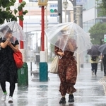 猛烈な風雨の中、傘を差して歩く人たち＝１５日午前９時４４分、神戸市中央区（撮影・鈴木雅之）