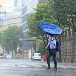 お盆と台風の影響で人けの少ない神戸・元町を、傘を差して歩く人＝１５日午前９時３２分、神戸市中央区（撮影・鈴木雅之）