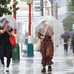 猛烈な風雨の中、傘を差して歩く人たち＝１５日午前９時４４分、神戸市中央区（撮影・鈴木雅之）