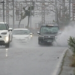激しい雨が降り続く中、水しぶきを上げて走る車＝１５日午前１１時２６分、神戸市須磨区一ノ谷町５（撮影・小林良多）