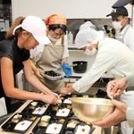 夏休みを学童保育で過ごす子ども向けの弁当を用意する留学生ら＝神戸市兵庫区、子ども食堂「コロコロおむすび」