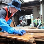 泥をかぶった床板を洗うボランティア＝１８日、美町香住区間室