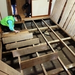 泥をかぶった床板を清掃するボランティア＝１８日、香美町香住区間室