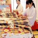 子どもたちの健康を祈り、千歳飴の袋詰め作業に取り組む巫女ら＝中央区下山手通１、生田神社