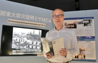 賀川記念館にある関東大震災に関するコーナーで、賀川豊彦の精神について語る同館参事の田中重至さん＝神戸市中央区吾妻通５、同館