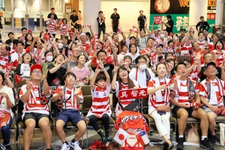 日本代表のユニホームを着て、歓声を上げるパブリックビューイングの来場者＝１０日夜、神戸ハーバーランドのスペースシアター