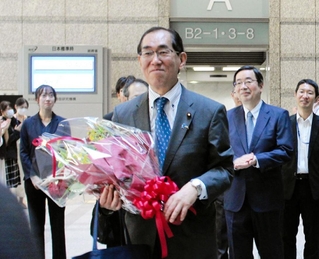 花束を手に総務省を後にする松本剛明氏＝東京都千代田区