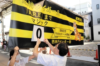 のりつくだ煮のラベルが「優勝！」に変わる特別ステッカーを配る「おっ！サンの店」＝デュオこうべ