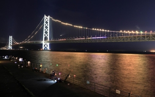 阪神優勝を祝って、しま模様のタイガースカラーを演出した明石海峡大橋＝１５日夜、神戸市垂水区東舞子町、舞子公園（撮影・小林良多）