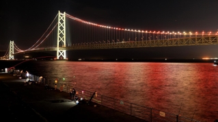 阪神優勝を祝福する紅白のライトアップが始まった明石海峡大橋＝１５日夜、神戸市垂水区東舞子町、舞子公園（撮影・小林良多）