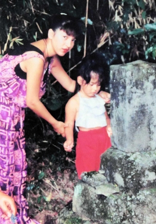 母ディビナさんと、先祖の墓参りをする３歳の熊川しずこさん＝１９９５年８月、佐賀県（本人提供）