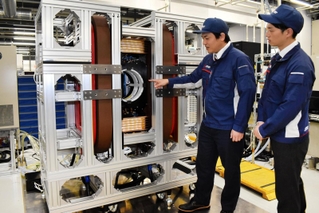 試作機の磁場が発生する空洞部を指さす野村航大さん（左）と鷲野将臣さん＝尼崎市塚口本町８、三菱電機先端技術総合研究所