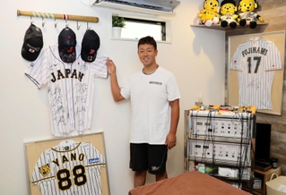 治療院を営む手嶋秀和さん。院内には選手の直筆サイン入りユニホームなどが飾られている＝西宮市浜甲子園１