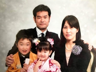 ２０１２年２月に撮影した家族写真。夫の隆司さん（後列左）はこの約２カ月後に亡くなった（岡真裕美さん提供）