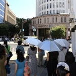 あまりの暑さに、日差しを避けて信号待ちをする人たち＝８月１２日、神戸市中央区三宮町３