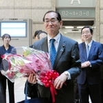 花束を手に総務省を後にする松本剛明氏＝東京都千代田区