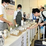 出発前に播磨の地酒を試飲する乗客ら＝ＪＲ姫路駅
