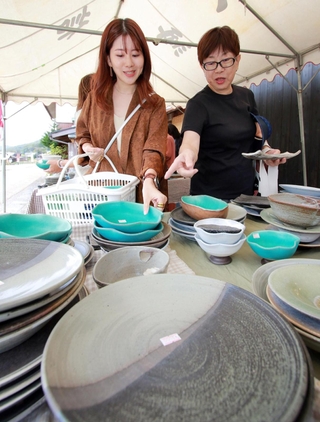 ずらりと並んだ陶器からお気に入りの品を探す陶芸ファンら＝５日午前、丹波篠山市今田町上立杭