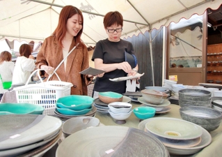 ずらりと並んだ陶器からお気に入りの品を探す陶芸ファンら＝丹波篠山市今田町上立杭