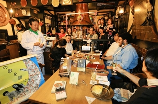 ノーベル賞受賞ならずも、来年の吉報に期待を寄せあいさつする山中崇裕さん（左）とハルキストら＝５日夜、神戸市中央区中山手通２、ピノッキオ（撮影・長嶺麻子）