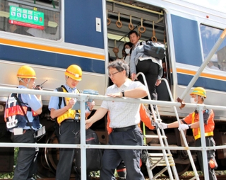 はしごを使い、駅間に停車した電車から降りる訓練参加者ら＝神戸市兵庫区駅南通５