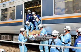訓練で急病人役を担架に乗せて電車から降ろす救急隊員ら＝神戸市兵庫区駅南通５