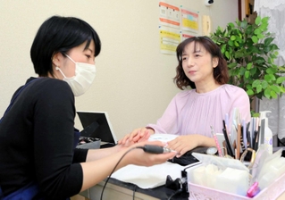 視覚障害者向けの出張ネイルサロンを経営する佐藤優子さん（左）