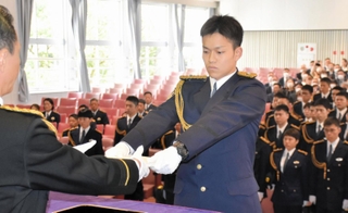 村井紀之兵庫県警本部長（左）から人事異動通知書を受け取る初任科生ら＝県警察学校