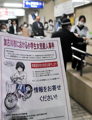 ビラを配り、情報提供を呼びかける捜査員＝１６日午後、加古川市別府町朝日町