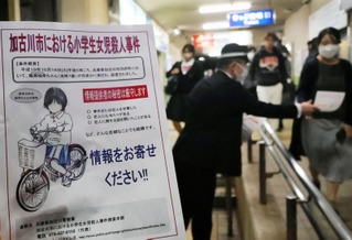 ビラを配り、情報提供を呼びかける捜査員＝１６日午後、加古川市別府町朝日町