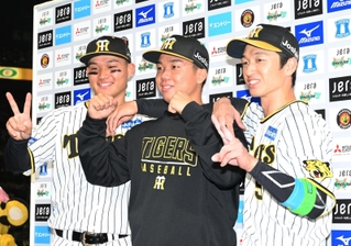 ＣＳファイナル初戦に勝利し、ヒーローインタビューのお立ち台で写真撮影をする同じ淡路島出身の阪神の村上（中央）と近本（左）＝１８日夜、西宮市の阪神甲子園球場（撮影・風斗雅博）