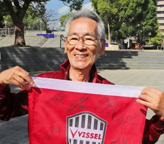 選手のサインを集めた旗を前に期待を寄せる田村勝太郎さん＝神戸市長田区
