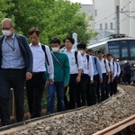 避難誘導訓練で駅間に止まった電車から降り、線路上を歩く人ら＝６日午後、神戸市兵庫区