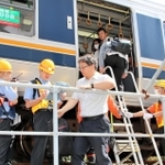 はしごを使い、駅間に停車した電車から降りる訓練参加者ら＝神戸市兵庫区駅南通５