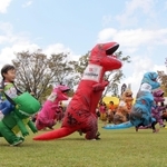 恐竜の着ぐるみを着て走る子どもたち＝１５日午後、丹波市柏原町田路、丹波年輪の里
