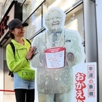 設置された「おかえり！カーネル」の等身大パネルに手を置くファン＝兵庫県西宮市、ケンタッキーフライドチキン阪神甲子園店