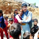 シリアとの国境付近で、難民キャンプの子どもたちに囲まれる佐々木美和さん＝８月、レバノン（神戸国際支縁機構提供）