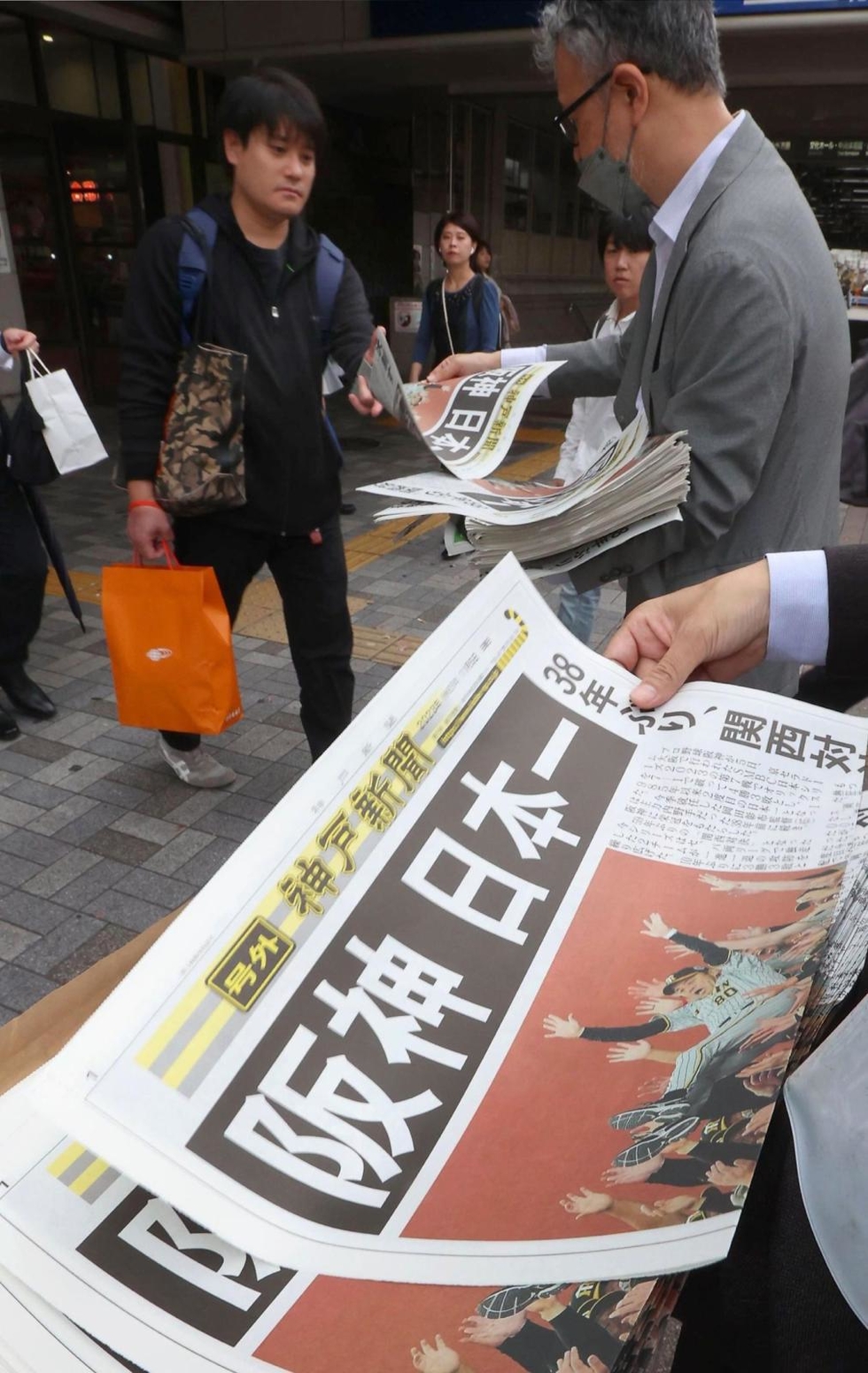 号外はトラ柄! 38年ぶり「阪神日本一」 神戸新聞が配布、一